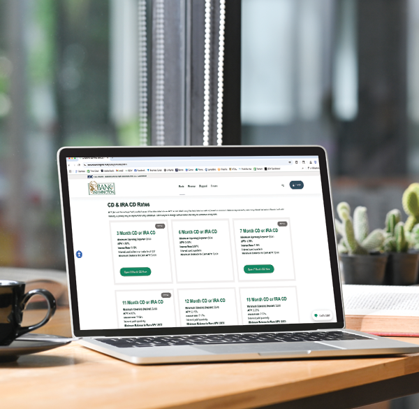 laptop with Bank of Washington CD rates and IRA rates sitting on a wood desk