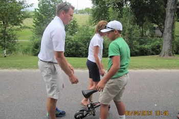 Bank of Washington Executive Vice President helping kid on mini bike