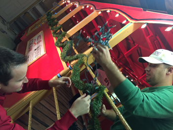 Bank of Washington employees adding lights to red trolley for Holiday parade