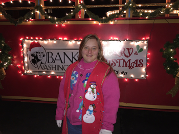Bank of Washington employee in front of red trolley decorated with Christmas lights
