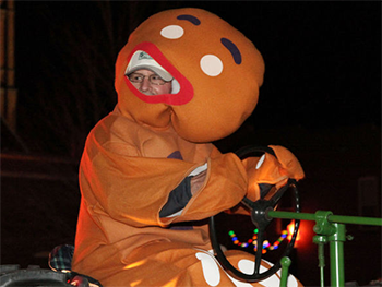Bank of Washington employees dressed as Gingerbread Man driving a tractor for the 2015 Holiday Parade of Lights