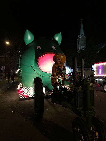 Bank of Washington employees dressed as Gingerbread Man driving a tractor pulling the big inflatable pig dressed as Rudolph for the 2015 Holiday Parade of Lights