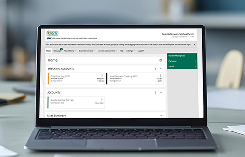 Laptop on desk displaying Bank of Washington's digital banking homepage 