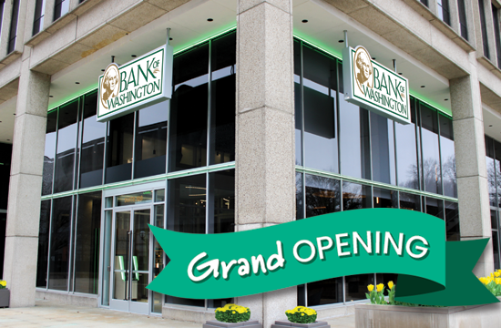 Bank of Washington's Clayton branch exterior with grand opening banner and yellow flowers on right hand side