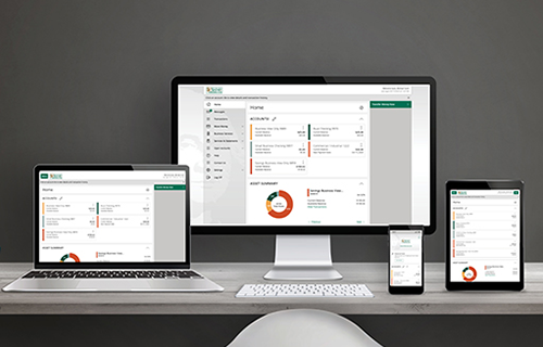 a laptop, computer, keyboard, iphone, and ipad all opened to Bank of Washington's moblie banking platform